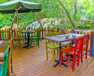Aksu, Türkiye - 9 Mayıs 2017: Renkli ahşap mobilya orman, Kurşunlu Şelalesi bankada 9 Mayıs Aksu, Türkiye'de bulunan kahve evin yaz terasında.