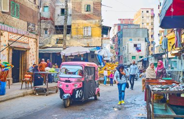 Alexandria, Mısır - 18 Aralık 2017: 18 Aralık Alexandria gecekondu Karmouz, bölge, sokakta bulunan parlak tuk-tuk riides gıda pazarında.