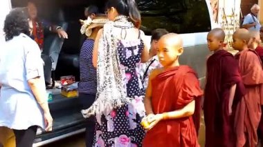 Bagan, Myanmar - 25 Şubat 2018: Asya turistler üzerinde 25 Şubat Bagan içinde Shwe Gu Budist Eğitim Manastırı, acemi rahipler (samaneras) için bağış yetim getirmek.