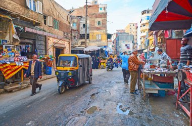 Alexandria, Mısır - 18 Aralık 2017: Karmouz İlçesi, tuk tuks ve araçların kalabalık caddede binmek gecekondu, gıda tezgahları ve yerel Souk (Pazar), çay evleri arasında 18 Aralık İskenderiye.
