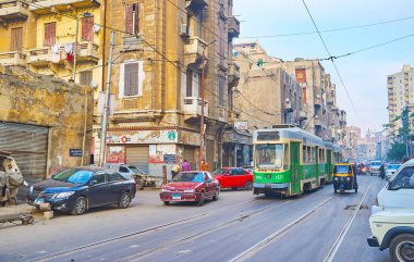 Alexandria, Mısır - 18 Aralık 2017: Eski yeşil tramvay Al Madina satır sürücüler üzerinde Aralık 18 Alexandria El Labban mahallede eski püskü Şerif Avenue boyunca.