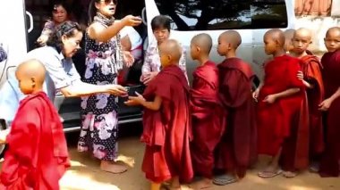 Bagan, Myanmar - 25 Şubat 2018: Hacılar tatlılar öksüz - Shwe Gu Budist Eğitim Manastırı, acemi rahipler (samaneras) 25 Şubat Bagan içinde vermek.