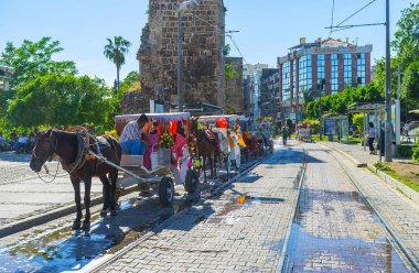 Antalya, Türkiye - 11 Mayıs 2017: Atlı arabaları satır temel ve Cumhuriyet Caddesi'nin antika surları 11 Mayıs Antalya Park.