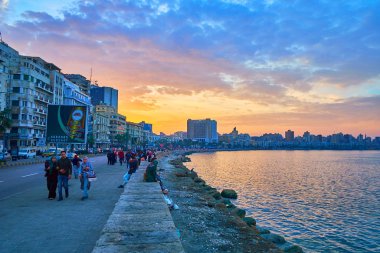 Alexandria, Mısır - 18 Aralık 2017: Sahil mesire - Corniche, günbatımı gökyüzü, Akdeniz'de, 18 Aralık Alexandria yansıtan bir görünüm ile romantik yürüyüş için en iyi yer olduğunu.