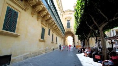 Valletta, Malta - 17 Haziran 2018: Eski tiyatro sokak menziller yan duvar boyunca büyük usta'nın Sarayı ve Cumhuriyet Meydanı kesilmiş ağaç manzaralı Palace arch, 17 Haziran'da Valletta. 