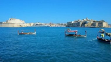Valletta, Malta - 17 Haziran 2018: Dghajsa ve luzzu geleneksel Malta tekneler ocağı Wharf, Birgu ve Senglea, 17 Haziran'da Valletta müstahkem şehir manzaralı.