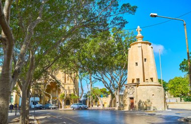 Gölgeli Sarria sokağın Wignacourt su kulesi ve Robert Samut salonu, arka planda, Floriana, Malta bilinen eski Methodist Kilisesi manzaralı.