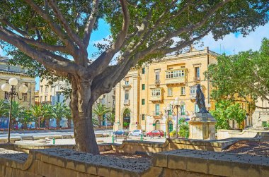 Relax in shade of lush park, situated on Robert Samut square in Floriana, Malta. clipart