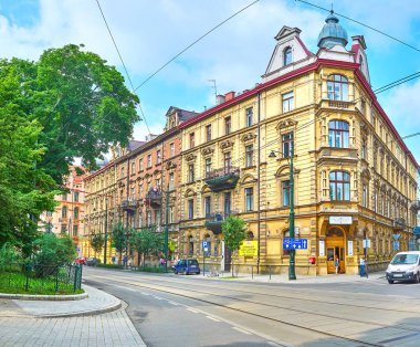 Krakow, Polonya - 11 Haziran 2018: Tarihi yapılar/Mimariler komşuları ile 11 Haziran Krakow Podwale Caddesi üzerinde şehir parkları.