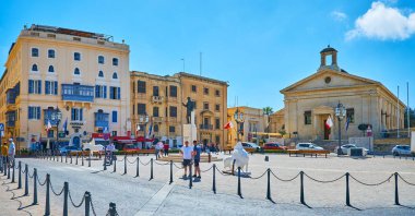 VALLETTA, MALTA - JUNE 17, 2018: Panorama of Castille Place with statue of George Borg Olivier in the middle and the former Garrison Chapel, known as Casino della Borsa and serving as Malta Stock Exchange, on June 17 in Valletta. clipart
