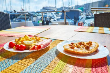 İki sandviç - peynir, yumurta, domuz pastırması ve domates ve tatlı tatlı biri ile sıradan bir - Hindistan cevizi yağı ve farklı fındık, Valletta, Malta ile tembel kahvaltı.