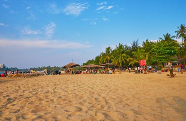 Chaung Tha, Myanmar - 28 Şubat 2018: Panorama sokak gıda satıcıları, satır yeşil palmiye ağaçları ve 28 Şubat Chaung Tha içinde döngüsü Kiralama noktası ile kum plaj.