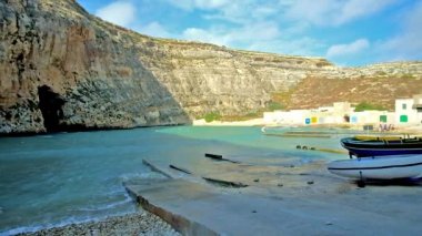 San Lawrenz balıkçı köyü küçük beyaz evler ve balıkçı tekneleri shore Dwejra iç deniz üzerinde uzun boylu kayalık uçurum, Gozo Adası, Malta ile Akdeniz kıyılarında ayrılmış.