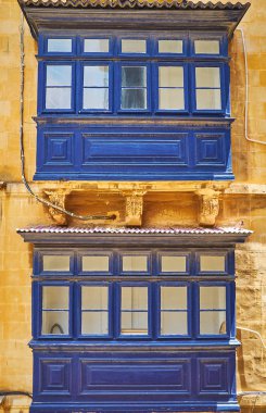 Geometrik desen ve taş çelenk, Valletta, Malta ile dekore edilmiş iki koyu mavi ahşap Malta balkon, yakın çekim.