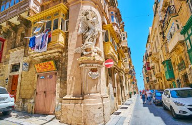 Valletta, Malta - 17 Haziran 2018: Panorama, St Ursula sokak köşesinde sıva heykeli St Michael, şeytan, 17 Haziran'da Valletta mücadele ile.