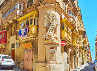 Valletta, Malta - 17 Haziran 2018: St Michael, niş olarak da adlandırılan köşe heykel, şeytan mücadele, Başpiskoposun ve St Ursula'nın sokakları Kavşağı, 17 Haziran'da Valletta içinde eski yapı süsle.