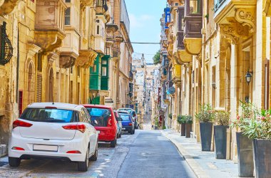 Walk along the tall densely built historical edifices and mansions of St Paul street, Valletta, Malta. clipart
