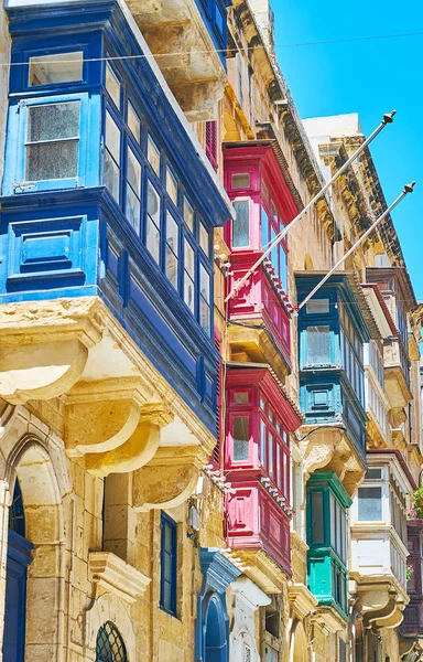 The eye catching wooden Maltese balconies, decorated with bright colors and reliefs, St Paul street, Valletta, Malta.