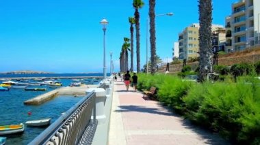 Bugibba, Malta - 14 Haziran 2018: Dawret Il-Gzejjer sahil mesire yeşillikler ve küçük balıkçı tekneleri Harbor, Haziran 14, Bugibba manzaralı boyunca tembel yürüyüş.