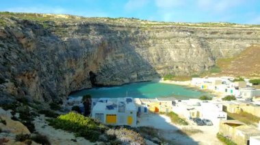 Dwejra iç denizi, büyük kayalık uçurum ve küçük beyaz evleri, balıkçı köyü, San Lawrenz, Gozo Adası, Malta ile çevrili güzel bir site.