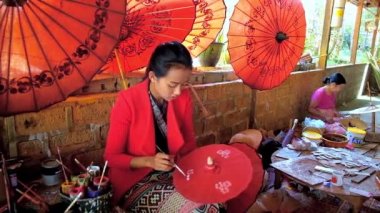 Pindaya, Myanmar - 19 Şubat 2018: Shan kağıt Atölyesi ressam 19 Şubat Pindaya içinde geleneksel çiçek desenli kırmızı el yapımı Birmanya şemsiye süsle.