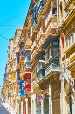 The dense Maltese balconies on facade walls of old edifices in St Dominic street, Valletta, Malta. clipart