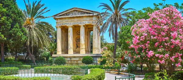 Alt Barrakka bahçeleri panoraması ile neoklasik Anıtı, uzun palmiye ağaçları, çiçek pembe ormangülü ve Çeşme, Valletta, Malta.