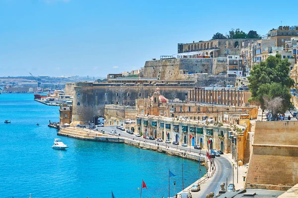 The fortress walls of Valletta open the perfect view on Quarry Wharf with medieval buildings, ramparts, bastions and boats in harbour, Valletta, Malta.