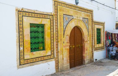 Doğal Konağı'nın cephesi geleneksel at nalı Arapça kapı ve pencereler, ile dekore edilmiş çiçek desenleri kiremitli,: Sfax, Tunisia.