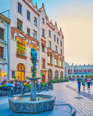 Krakow, Polonya - 11 Haziran 2018: Kentsel sahne eski Krakow iyi adam ile küçük çeşme ile heykel öğrenci Zaka ve Ana Pazar Sqaure yapılardır ve arka plan üzerinde 11 Haziran Krakow.