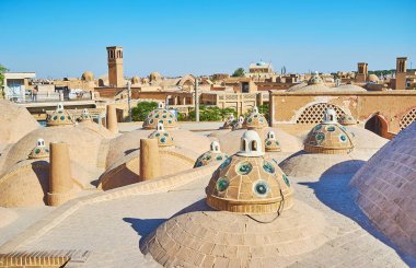 Tuğla kubbe arasında yürüyüş Ortaçağ windcatchers (badgirs) ve arka plan üzerinde: Kashan, Iran manzaralı Sultan Amir Ahmad (Qasemi Hamam) çatıda.