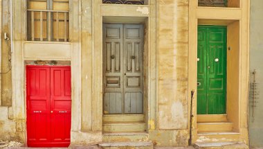 Üç eski parlak renkli kapı eski nane sokakta kırmızı zemin seviyesi düşük olan ve başka bir iki bazı adımlar, eski Nane sokak, Valletta, Malta var.