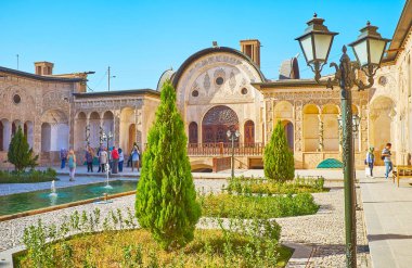 : Kashan, Iran - 22 Ekim 2017: Bahçe, Tabatabaei ile küçük ev genç mazı ağaçlarının, sekizgen çiçek yatak, çeşmeler ve 22 Ekim'de kaşan vintage sokak.