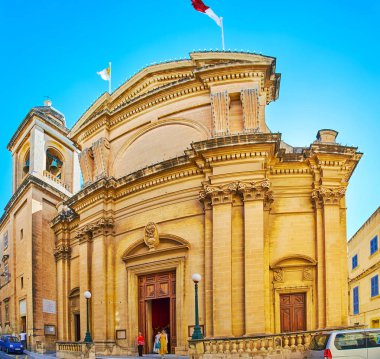 Birgu, Malta - 17 Haziran 2018: Oyma taş çelenk ve uzun boylu sütun, 17 Haziran'da Birgu dekore edilmiş büyük duyuru kilise taş cephe.