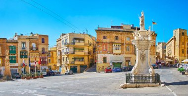 Birgu, Malta - 17 Haziran 2018: Dağlık manzara Zafer Meydanı (Misrah IR-Rebha) ile 17 Haziran'da Birgu içinde St Lawrence Heykelin arkasında eski binalar.
