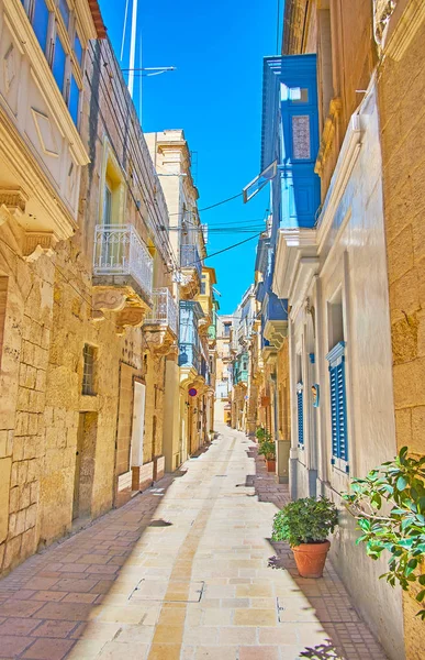 Ahşap Malta balkon, Birgu (Vittoriosa), Malta ile yerel kalker korunmuş eski yapılardır ile tarihi konut Mahallesi'nin dar sokakta yürümek.