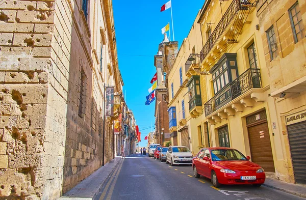 Birgu 马耳他 2018年6月17日 走在老街道以看法对检察官的宫殿的石头大厦和通告教会与旗子反对它 在6月17日在 Birgu — 图库照片