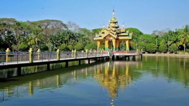 Theingottara Park lake tapınak Köprüsü ve bankalar, Yangon, Myanmar çevresinde yeşil ile temiz su yüzeyinde yansıtılır.