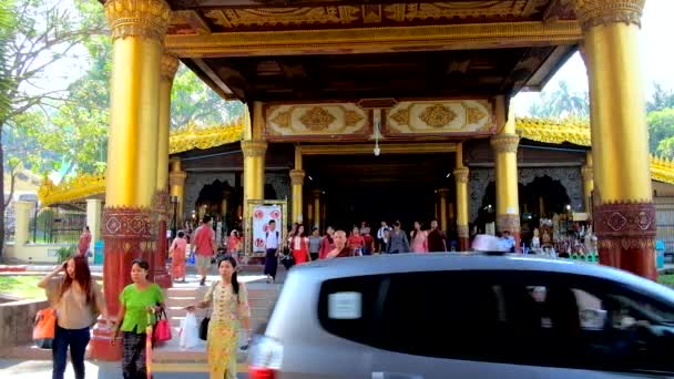ヤンゴン ミャンマー 2018 乗用の車や歩行者 日にヤンゴンのシュエダゴン パゴダの屋根付き市場の東のゲートのギャラリーのパスで実行されている道路を横断 — ストック動画