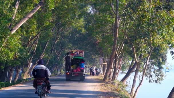 Nyaungshwe 2018年2月20日 沿城际公路沿线的交通与两侧绿树 旧卡车在其装货空间与村民乘坐 在2月20日在 Nyaungshwe — 图库视频影像