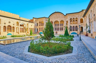 : Kashan, Iran - 22 Ekim 2017: Güzel süs Bahçe, Tabatabaei evin küçük ağaçlar ve arka plan, 22 Ekim'de kaşan pitoresk yaz terasında ortasında çeşme ile.