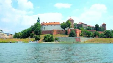 Korunmuş surlar, yüksek kuleleri ve yemyeşil yeşil bahçe etrafında, Krakow, Polonya Ortaçağ Wawel Kalesi görünümü açılarak Vistula Nehri kıyısında piknik keyfini çıkarın.