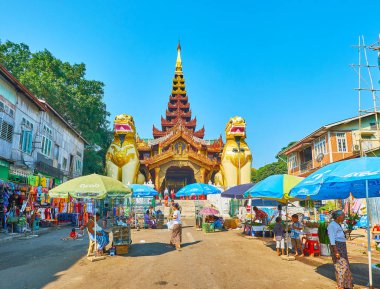 Yangon, Myanmar - 27 Şubat 2018: Pazar tezgahları çiçek ve meyve üzerinde 27 Şubat Yangon yapılan kapalı Galerisi, her iki tarafında dev leogryph veliler ile Doğu Kapısı Shwedagon Pagoda de dini teklifleri için