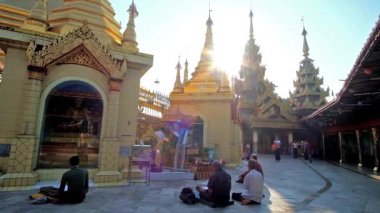 Yangon, Myanmar - 17 Şubat 2018: Sabah güneşi Sule Pagoda gerekçesiyle görüntü evlerin pyatthat çatılar üzerinden kulları üzerinde 17 Şubat olarak Yangon Lord Buddha imge vasıl dua parlar.