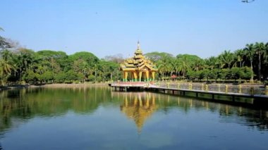 Gür yeşilliklerle, Yangon, Myanmar arasında altın Budist Tapınağı ile küçük bir göl ile pitoresk Theingottara park.