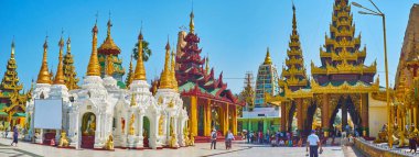 YANGON, MYANMAR - FEBRUARY 27, 2018: Panorama of Shwedagon grounds with Sacred Hair Relic Washing Well and Gautama Buddha Image House, located in Northern part of the complex, on February 27 in Yangon clipart