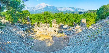 Yemyeşil çam ve grubunu Mount tahtalı arkasında sahne, Tekirova, Türkiye ile içinde Phaselis antik Roma amfi Panoraması.