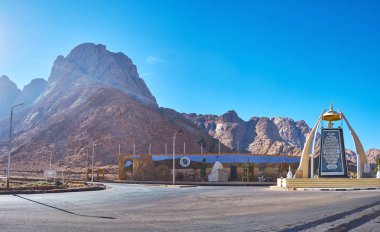 Dahab, Mısır - 25 Aralık 2017: Yol Kavşağı'nda Sina Çölü üzerinde 25 Aralık Dahab içinde dolambaçlı - ana Sina simge ve Suresi Kur'an-ı Kerim den mozaik görüntü büyük panelde, bileşimi heykel ile.