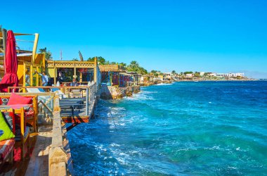 Dahab, Mısır - 25 Aralık 2017: Yaz sahil kafe teras üzerinde 25 Aralık içinde Dahab Akabe Körfezi'nin masmavi sularına yüzler.