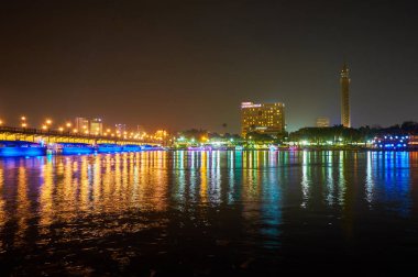 Şehrin gece ışıkları Qasr el Nil köprü bir görünüm ve Kahire Kulesi üzerinde Gezira Adası, Mısır Nil Nehri'nin sularına yansıyan